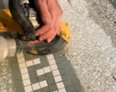 Using hand grinder to restore terrazzo floor. 